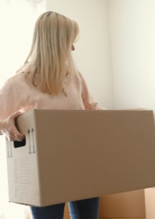 Warehouse staff member carrying a delivery box