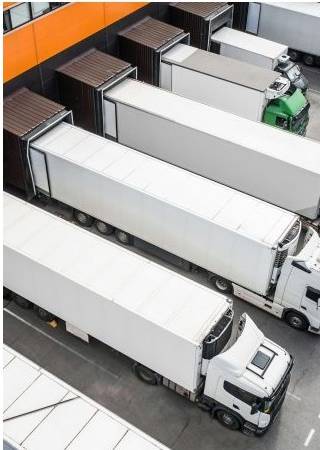 Fleet of delivery trucks at a distribution warehouse loading dock